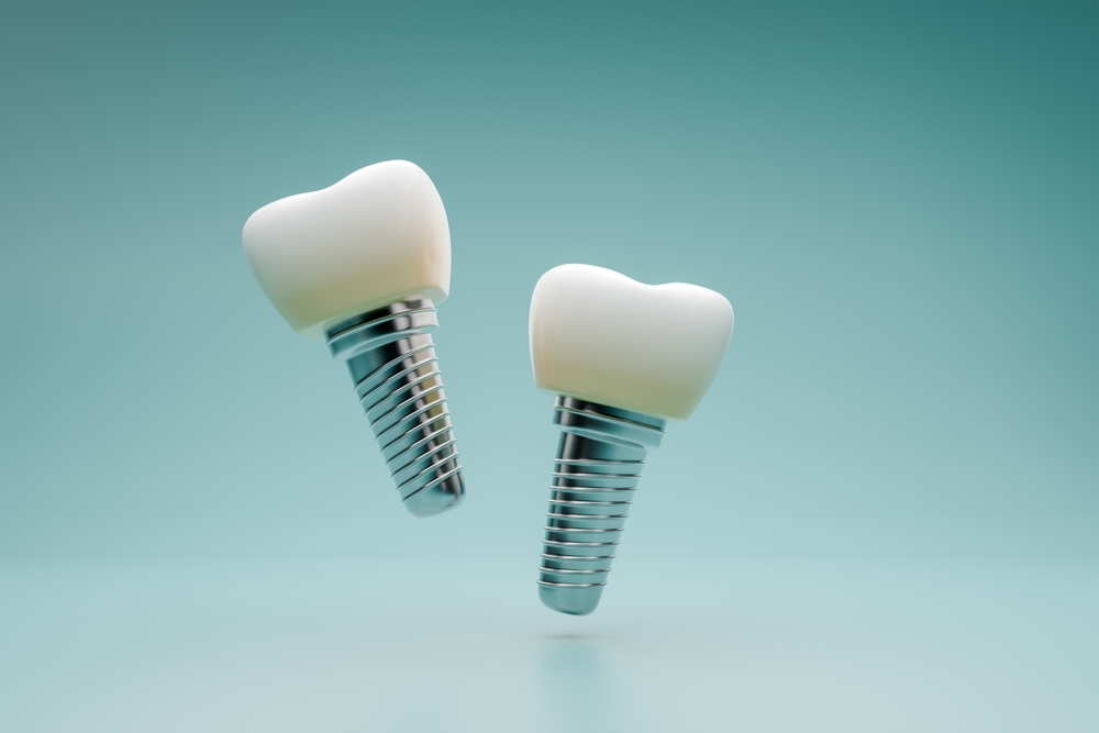 Two dental implants with white crowns and metallic screw bases are suspended in mid-air against a smooth, teal gradient background, resembling sleek dashboard components that highlight their modern clinical design.